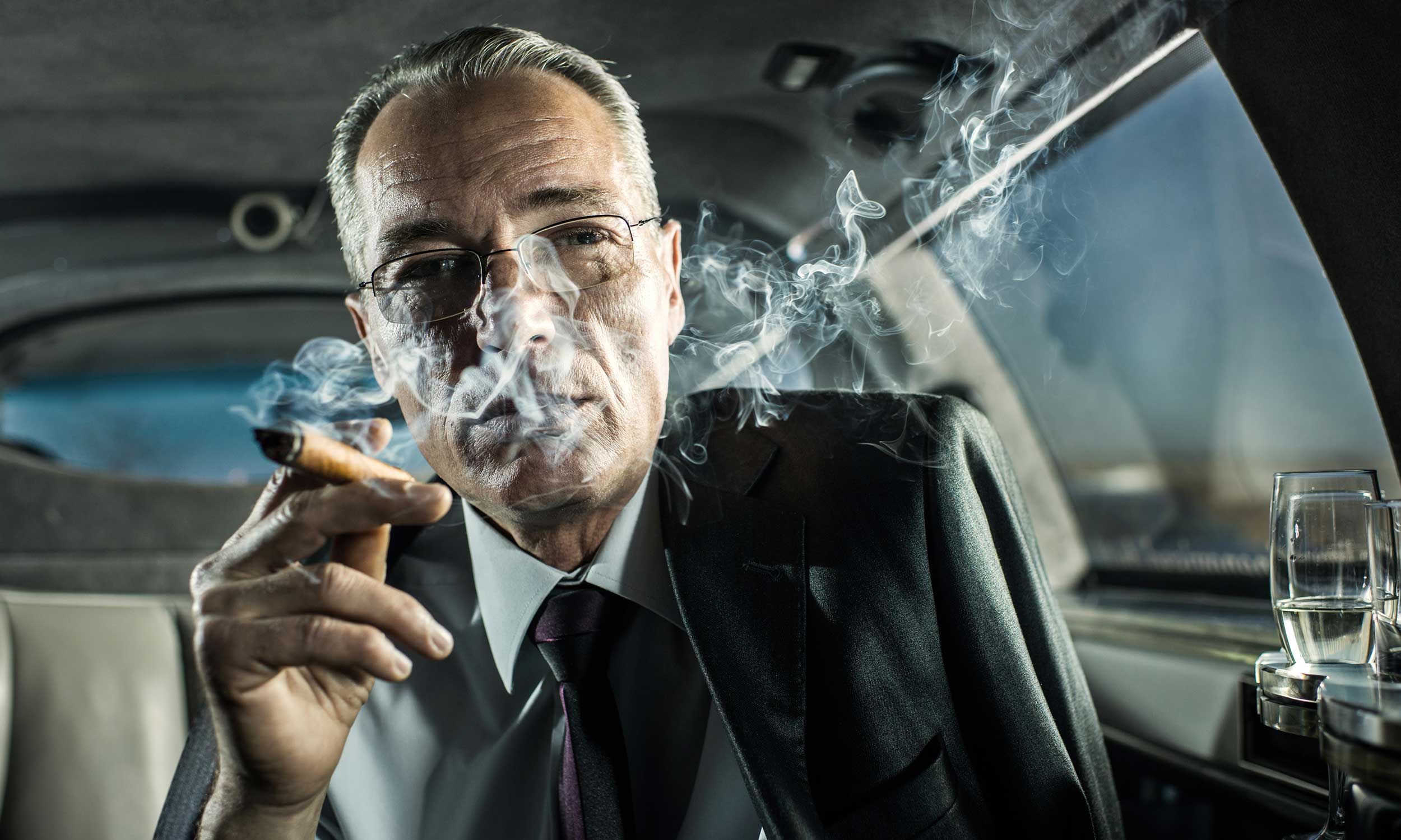 A tobacco executive smoking in a limousine