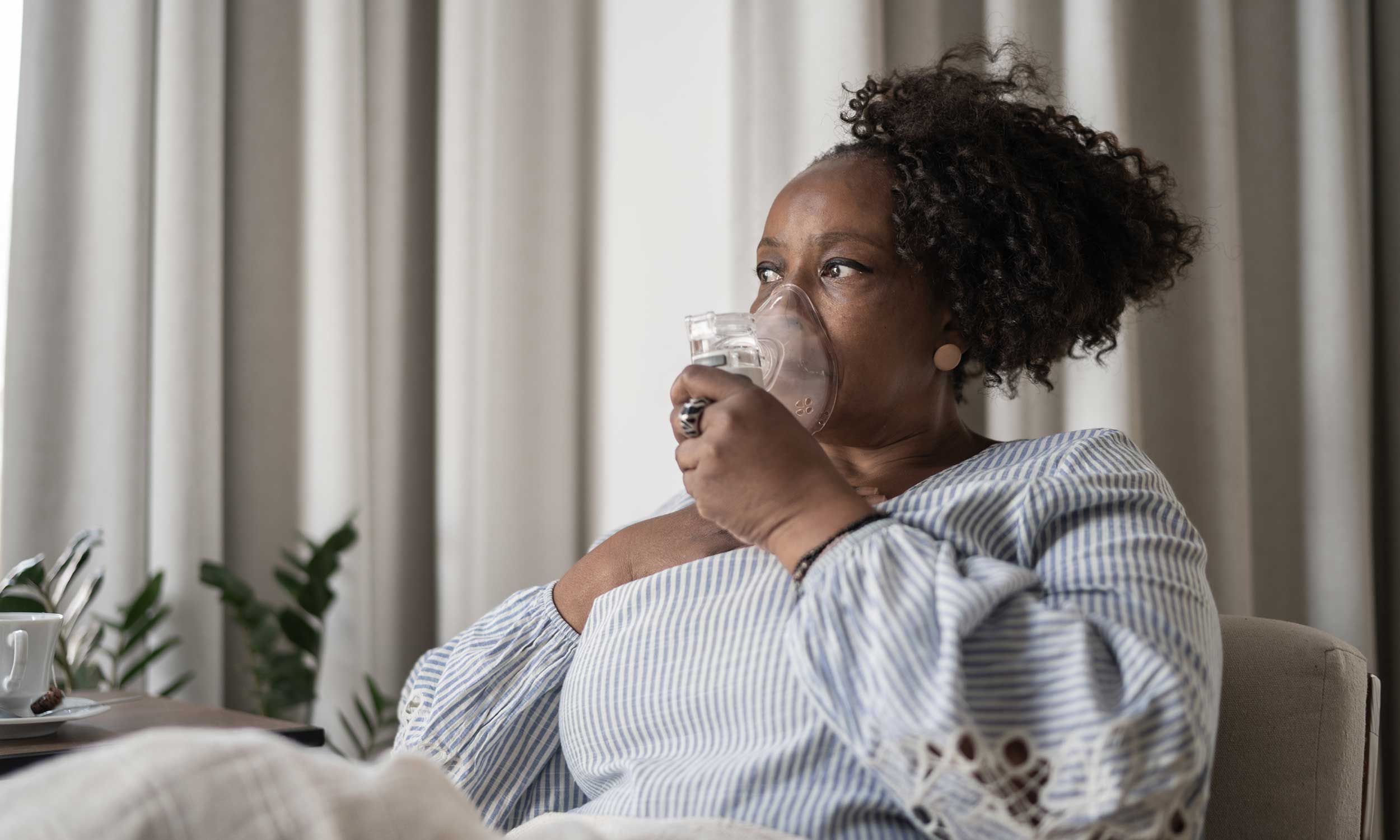 A woman suffering from COPD breathing using a mask